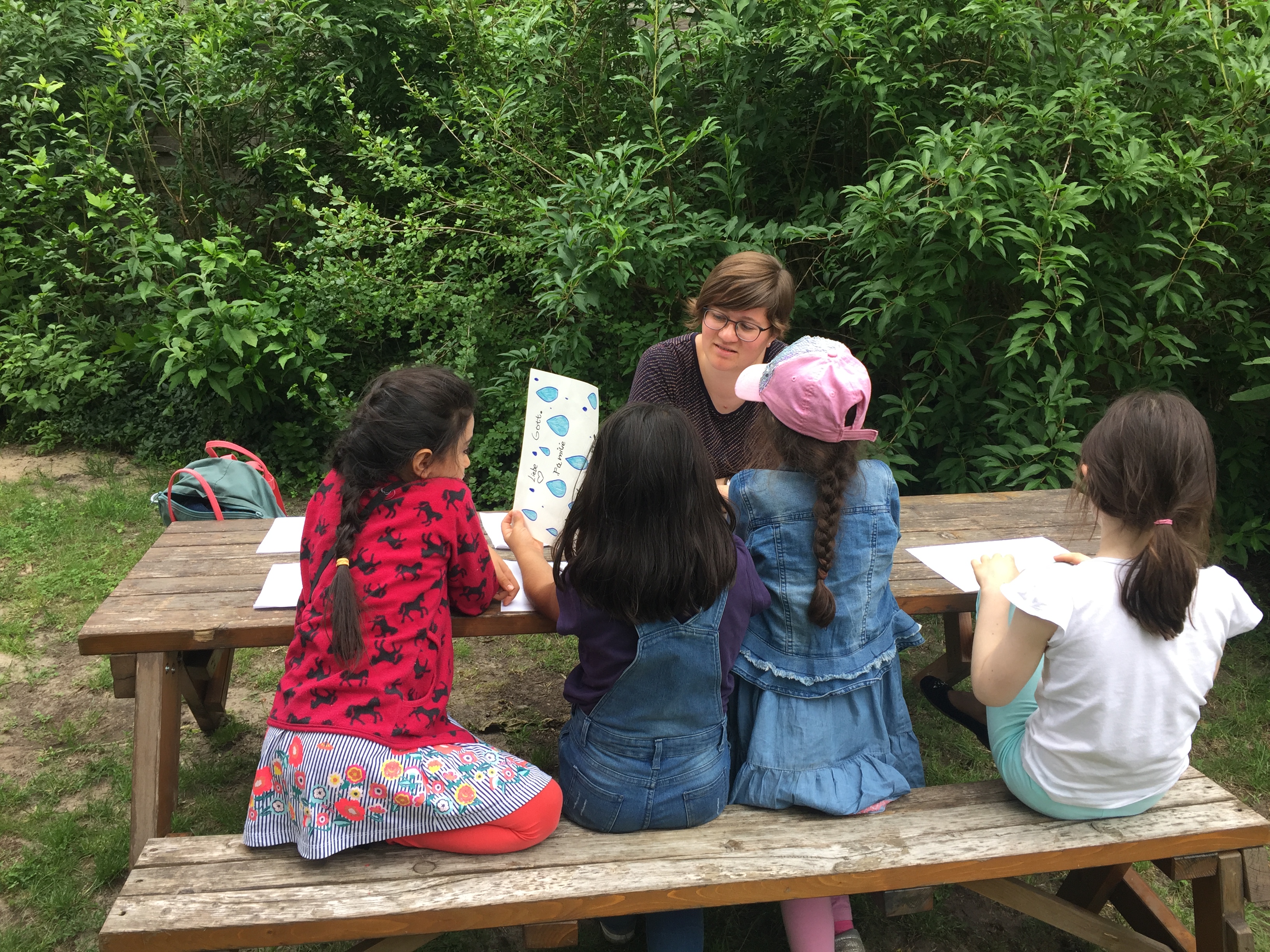 Girls enjoying a story and activity in the church garden.