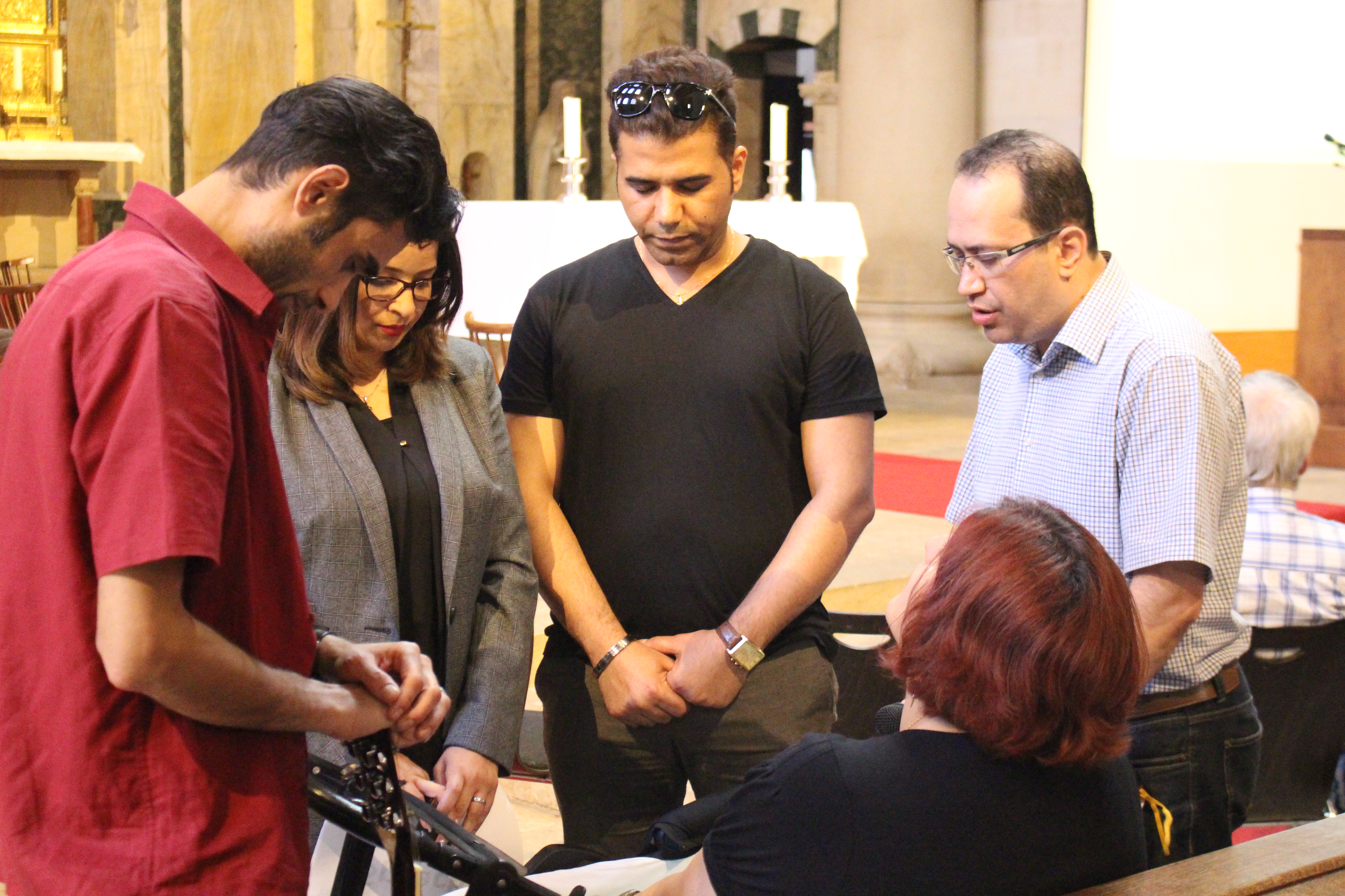 The leadership group of the Iranian Presbyterian Church Berlin praying before leading a prayer service.