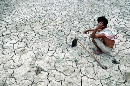 drought in s asia - dry land, man with hoe