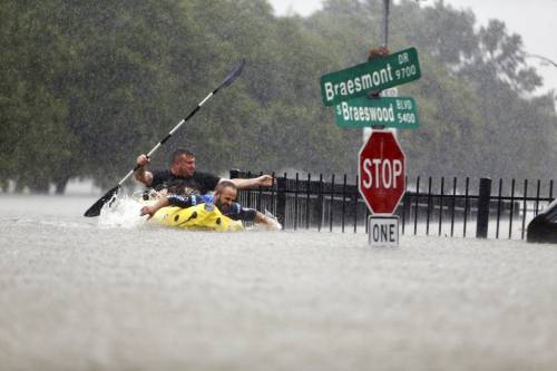 two men in inflatable boat in flood waters of houston