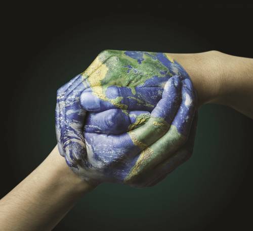 real hands clasped and a earth globe superimposed on them!