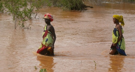 kenyan women wading in flood waters