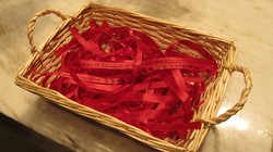 Red ribbons with writing on them in a basket