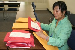 Peng Leong stuffing envelopes with Red Hands
