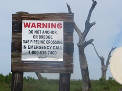 bayou fishing community oil warning sign